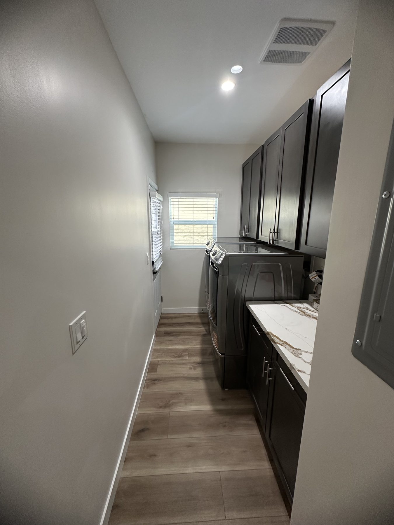 Laundry room with front-load washer and dryer, cabinets and folding counter at 1148 S Rimpau Blvd