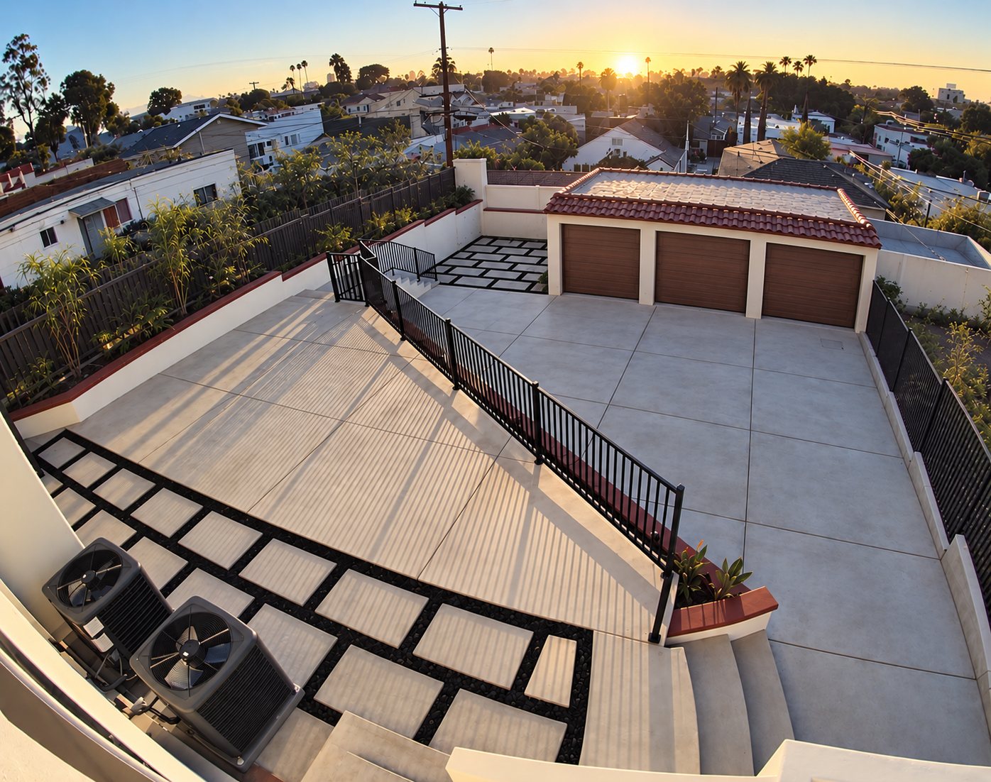 Shared backyard patio at 1148 S Rimpau Blvd as it is today, unfurnished, with stairs, concrete patio, paver path and detached garages